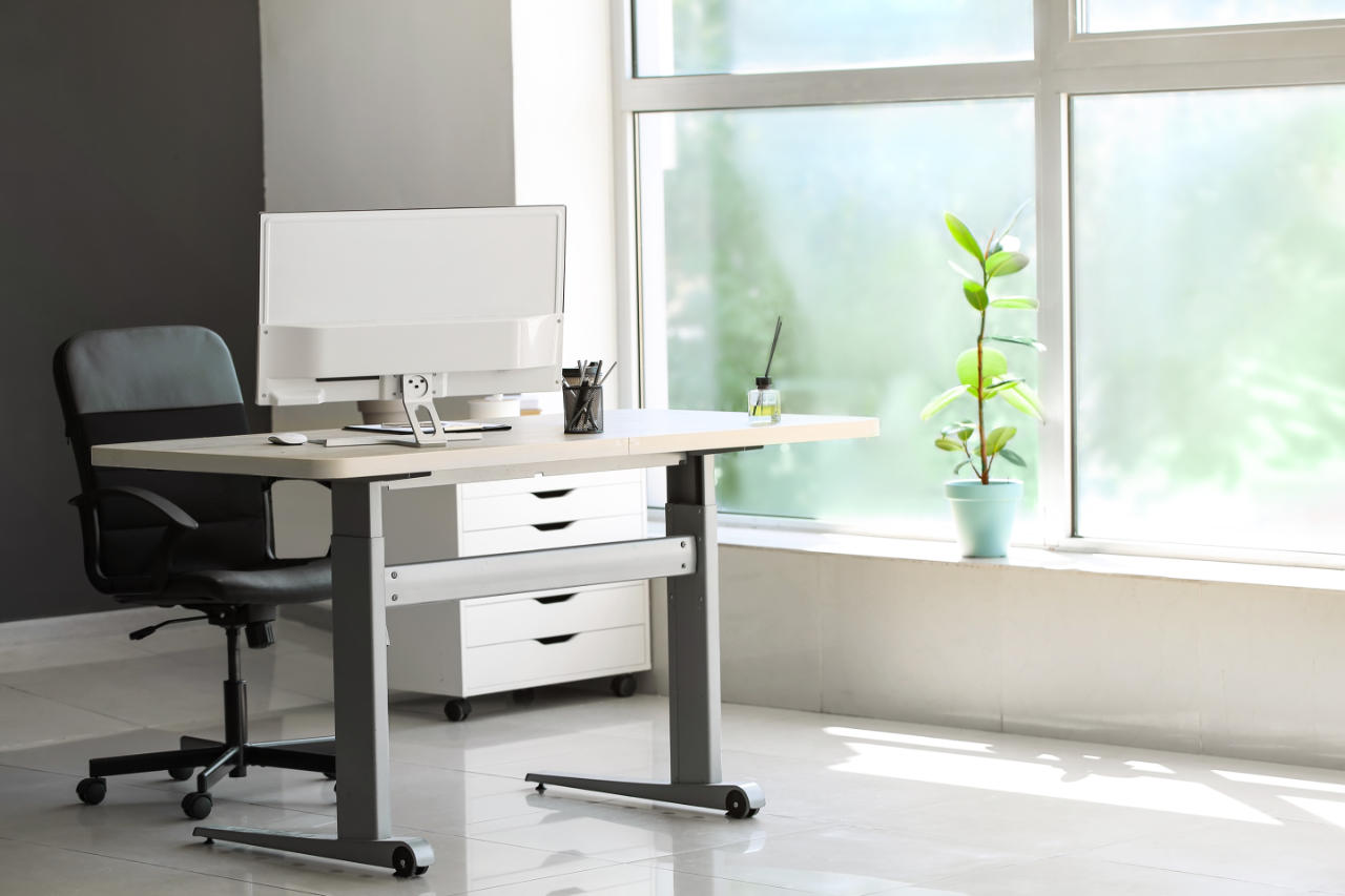 Height-adjustable standing desk in an office setting