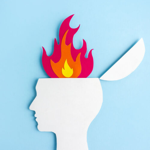 Stress awareness for employees Cardboard application of the silhouette of human head and flame.