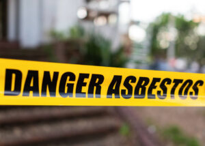 asbestos awareness – Yellow cordon tape warning of asbestos danger