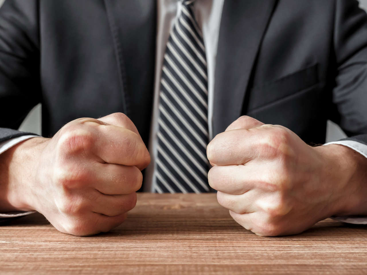 Conflict management angry man banging fists on table