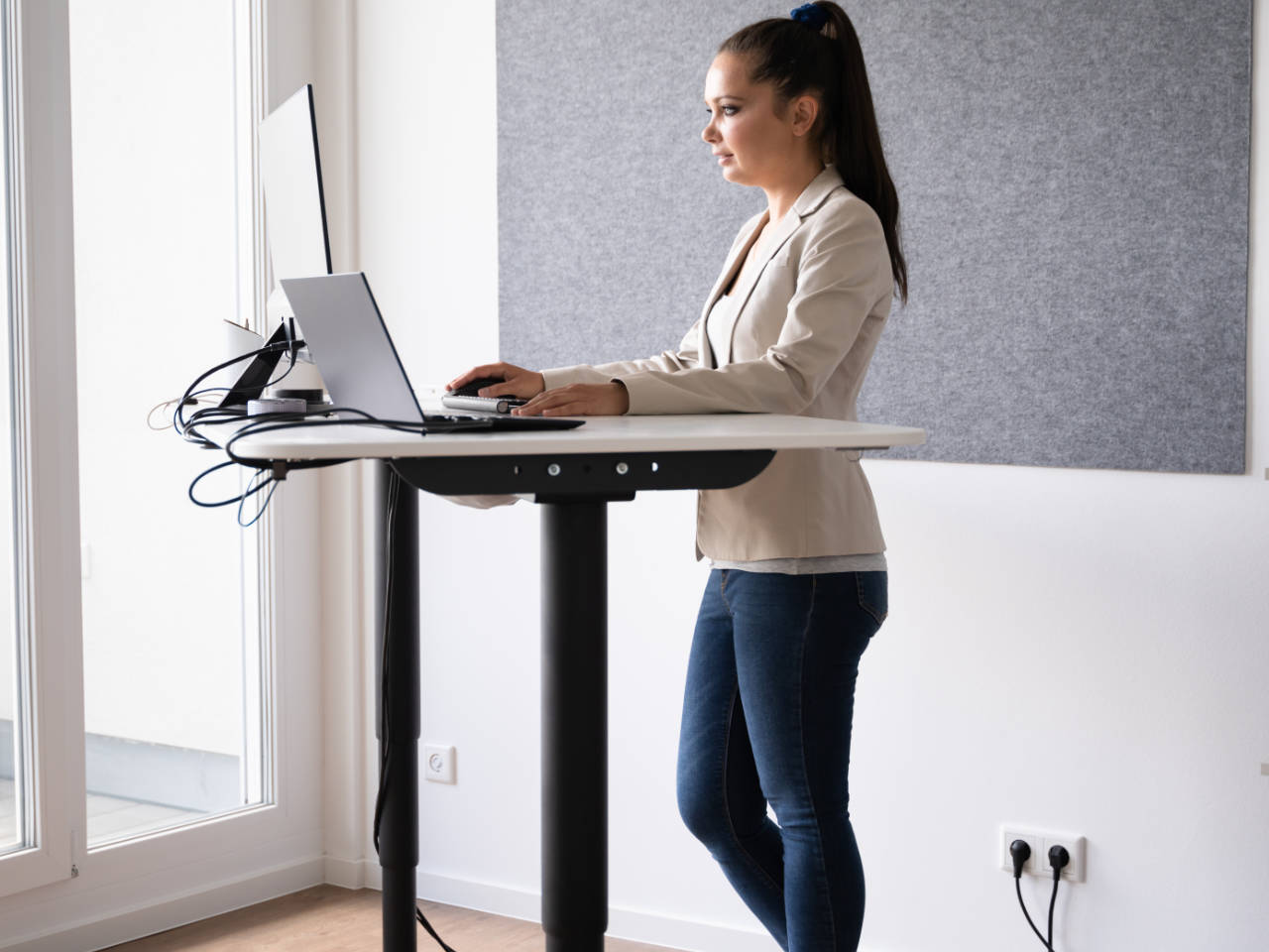A girl using an adjustable sit stand desk