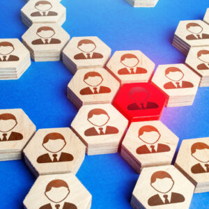 Wooden hexagons with graphics of faces on them fitting together like a puzzle. One is coloured red to illustrate disciplinary process.