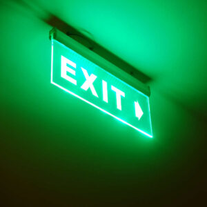 Photo of exit sign on a ceiling glowing green