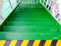 Green metal staircase marked with chevrons to indicate slips, trips and falls