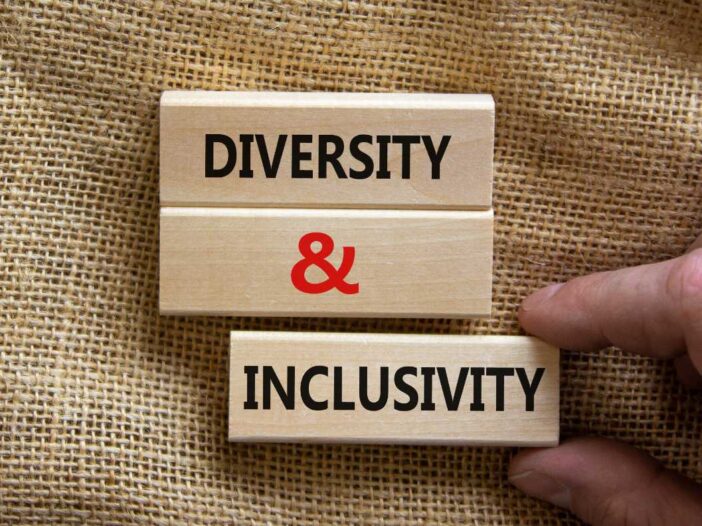 Wooden blocks form the words 'diversity and inclusivity' on canvas background.