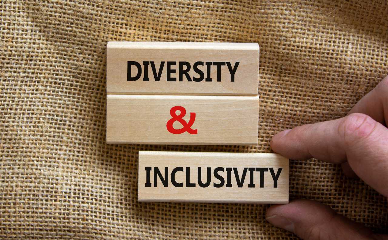 Wooden blocks form the words 'diversity and inclusivity' on canvas background.