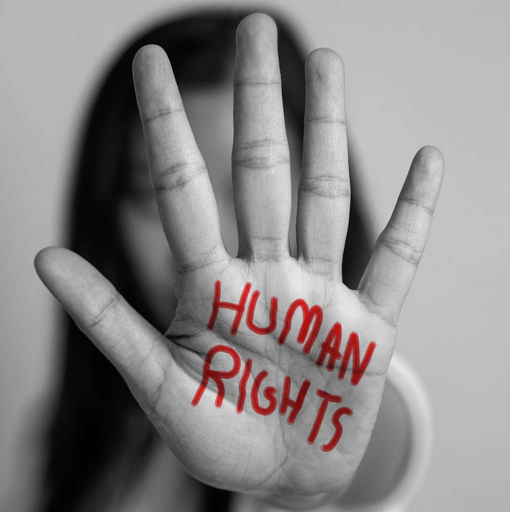 a hand held up in a stop gesture with 'human rights' written in bold red pen