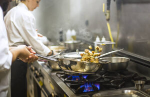 Restaurant health and safety – Chef preparing cuisine in hotel kitchen