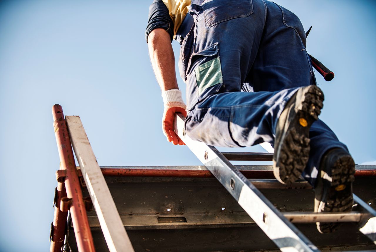 construction worker climbing a ladder onto scaffolding