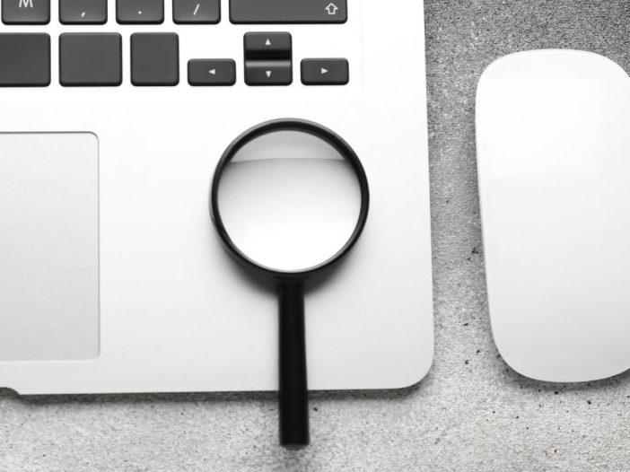 Image of magnifying glass and laptop