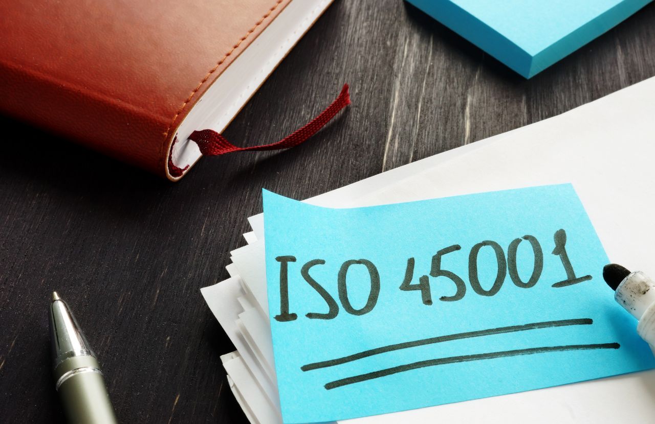 ISO 45001 written on a post-it note on a desk.