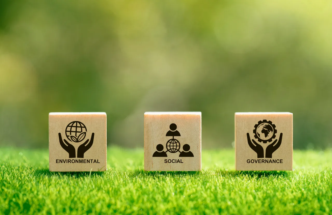 Three blocks on grass displaying words and symbols for environmental, social and governance