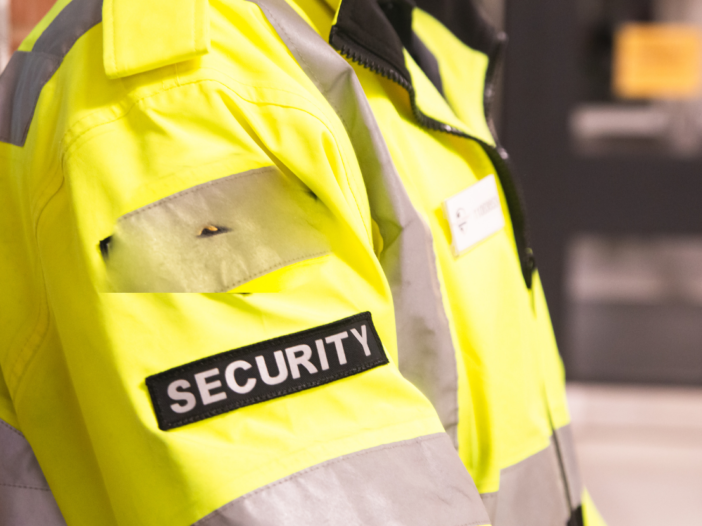 Close up of a security guard's arm with the security label prominently displayed