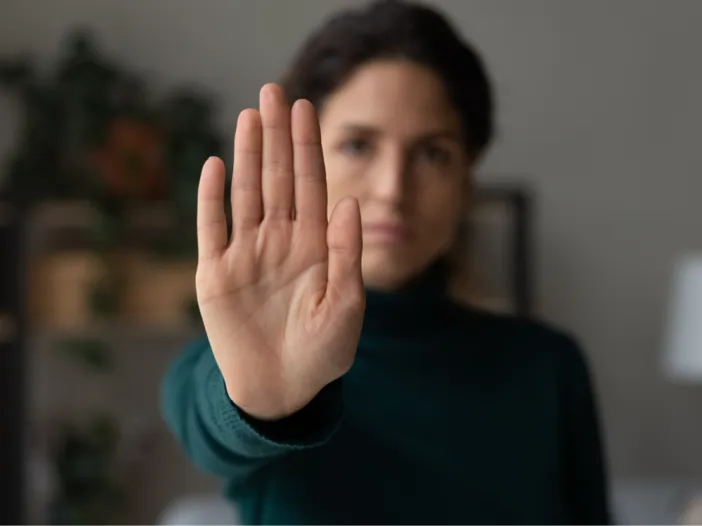 Sexual harassment training. Woman holding palm out in a stop gesture.