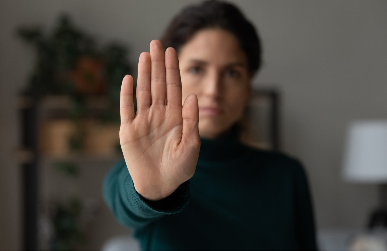 Sexual harassment training. Woman holding palm out in a stop gesture.