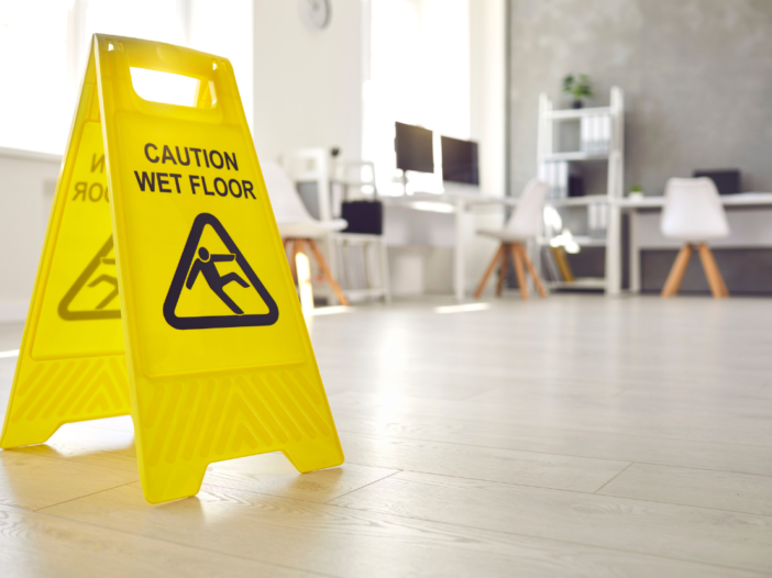 Yellow 'caution wet floor' sign on hardwood floor.