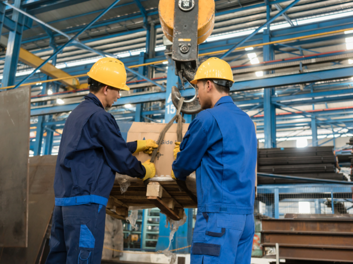 Two men in a warehouse operating lifting equipment to illustrate Lifting Operations and Lifting Equipment Regulations 1998