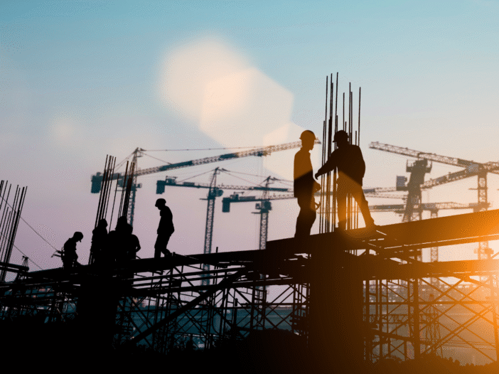 Construction workers on site at dusk