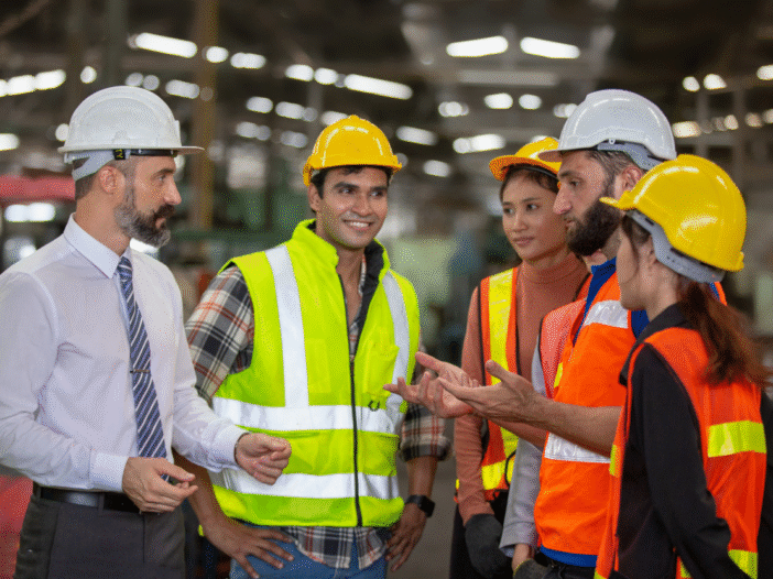 Construction workers talking to show communication in health and safety