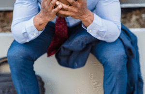Man with heads in his hands having been dismissed from his job