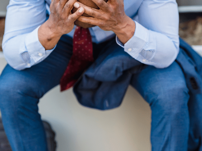 Man with heads in his hands having been dismissed from his job