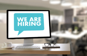 A computer screen displaying a speech bubble that says we are hiring.
