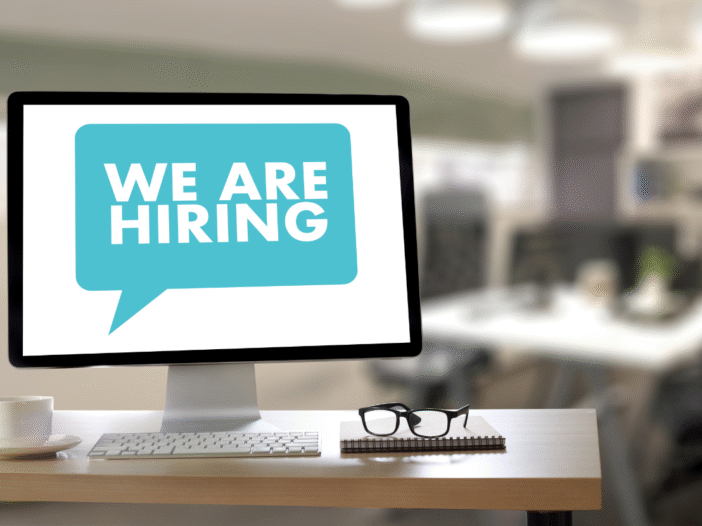 A computer screen displaying a speech bubble that says we are hiring.