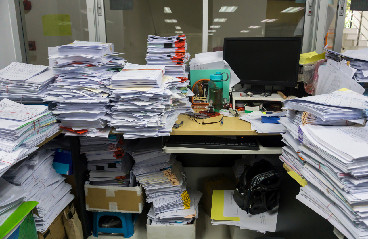 A cluttered desk buried in papers to illustrate poor fire safety housekeeping