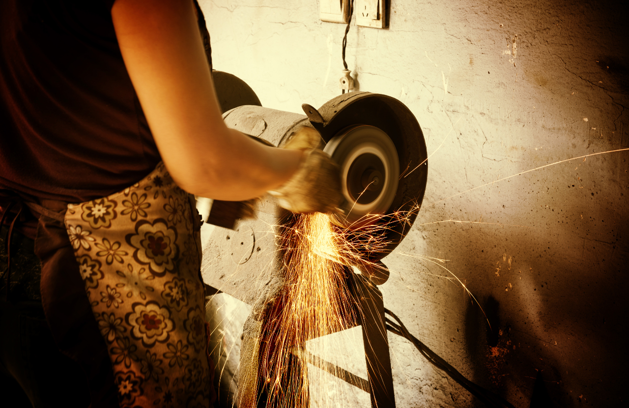 Woman in apron using an abrasive wheel