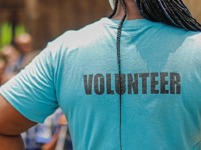 Volunteering Safety Training - Volunteer with braids wearing a blue 'Volunteer' shirt.