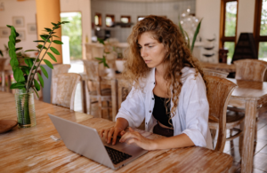 Woman working on laptop in cafe