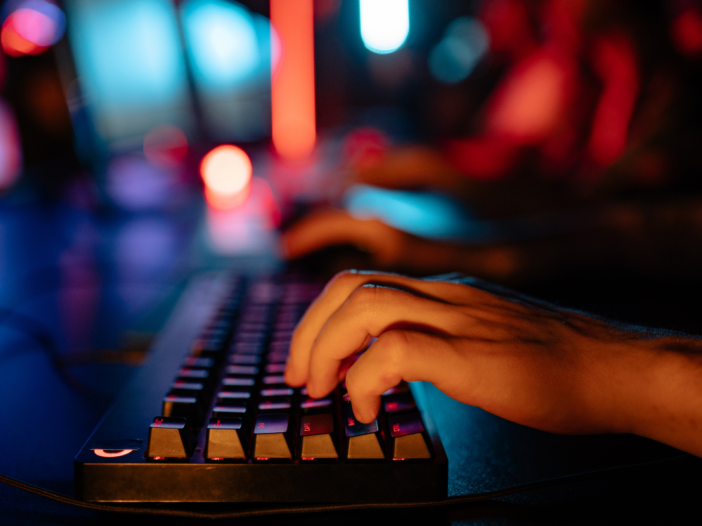 Someone typing on computer keyboard in dark