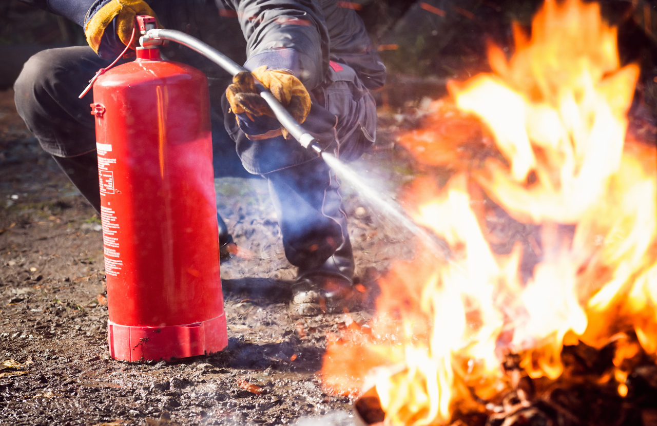 Firefighter putting out small fire with extinguisher