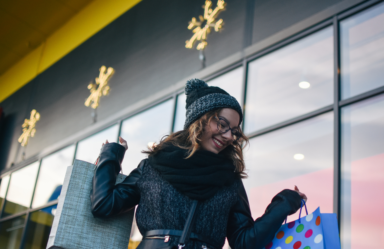 Happy woman carrying shopping backs to illustrate customer safety in retail stores