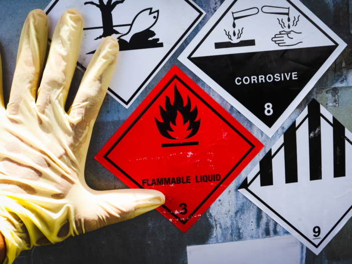 Hand in PPE and hazard symbols to illustrate COSHH guidelines