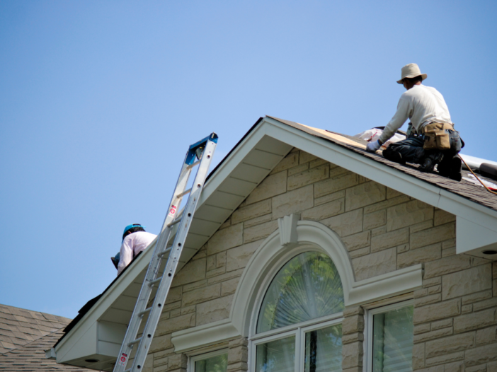 Contractors working on a roof to illustrate what is a construction phase plan