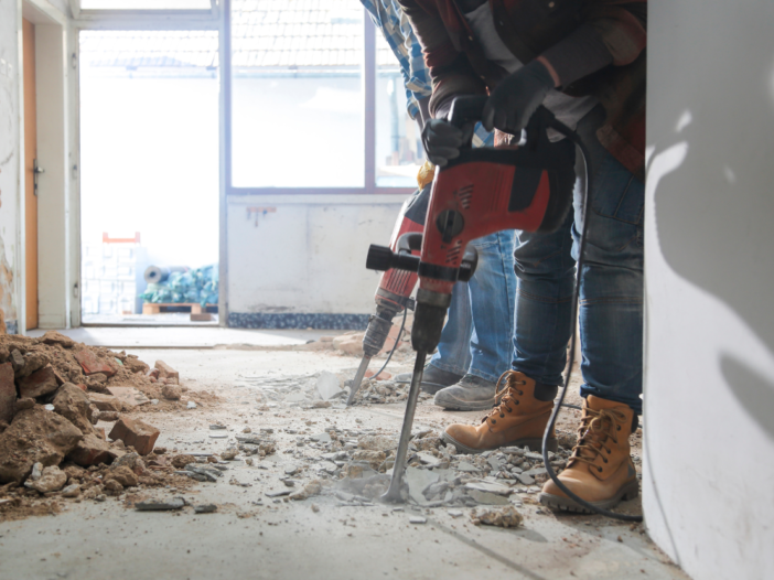 Contractor carrying out home improvements drilling into walls and floor to illustrate when does CDM apply