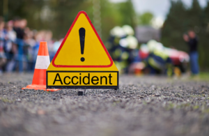 Yellow warning sign with 'accident' and cone in the middle of the road to illustrate accident and incident investigations