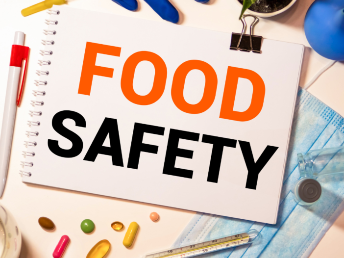 Notepad with typed words 'Food Safety' next to a pen and food stuffs, to illustrate danger zone for food