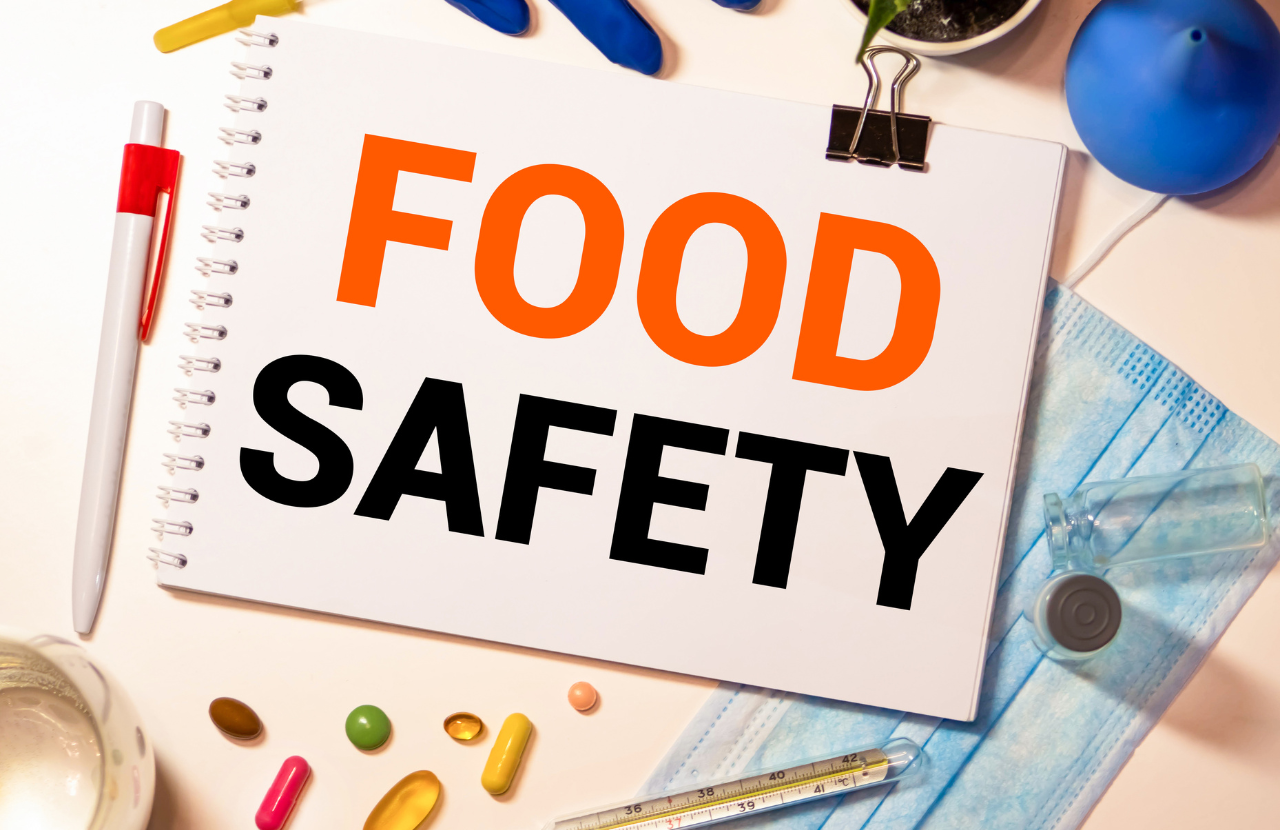 Notepad with typed words 'Food Safety' next to a pen and food stuffs, to illustrate danger zone for food