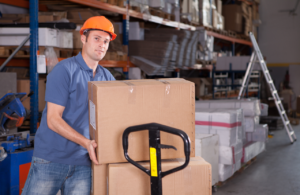 Man in warehouse with hard hat loading boxes onto a forklift to represent mhor meaning