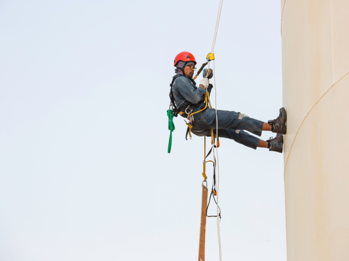 worker in ppe abseiling down a building to indicate working at height specialists